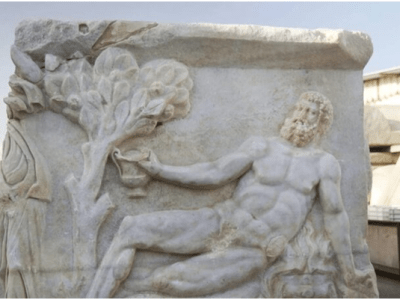 Drevni rezbarski crtež prikazuje grčkog boga kako pobeđuje rimskog heroja u — TAKMIČENJU U PIĆU